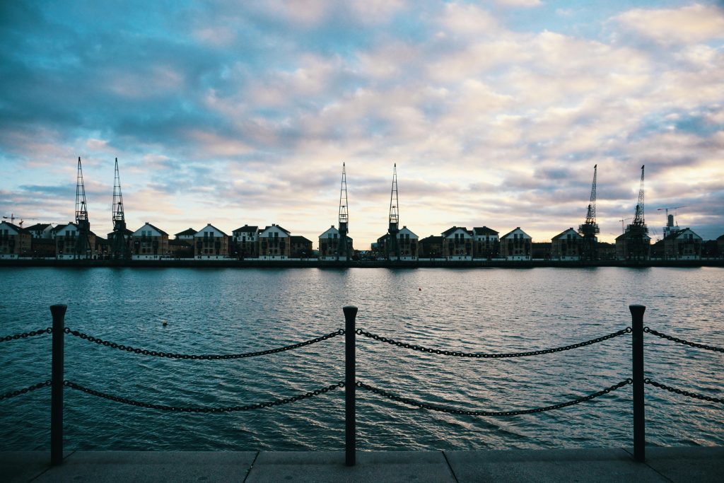 Captured from the London Docklands, showcasing the serene waterfront and industrial skyline at dusk.